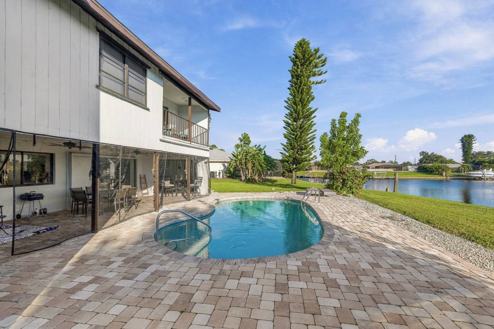 Back of the two-story house with the lanai and pool