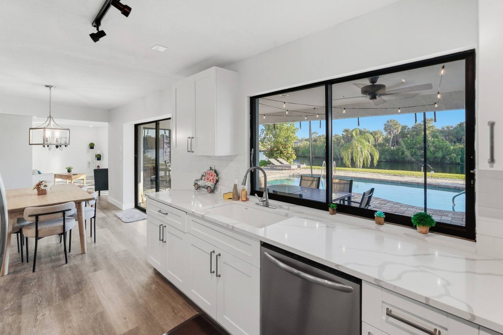 White kitchen with a window onto the pool